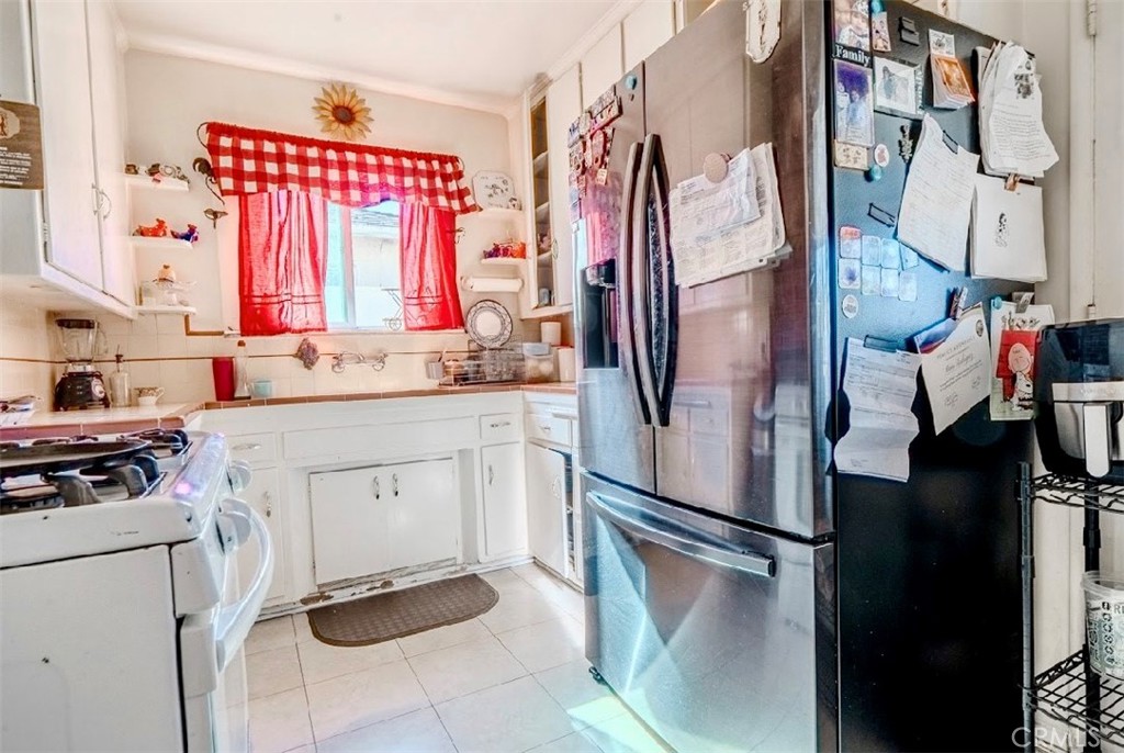 10539 Gridley Road Santa Fe Springs, CA 90670 - Photo 4 of 27 a kitchen with a refrigerator and white cabinets