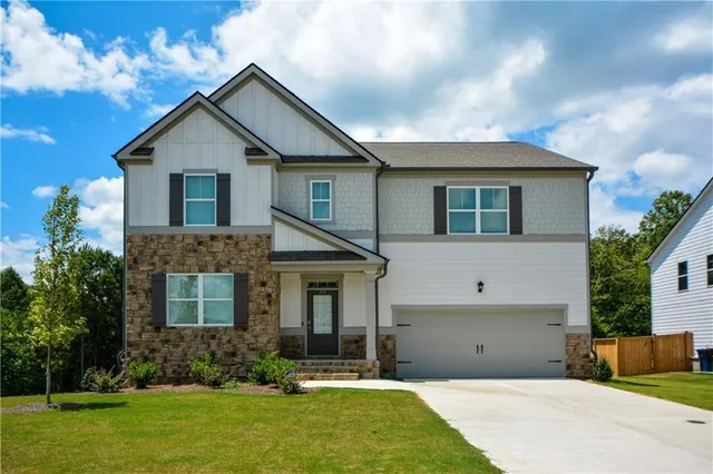 a front view of a house with a yard and garage