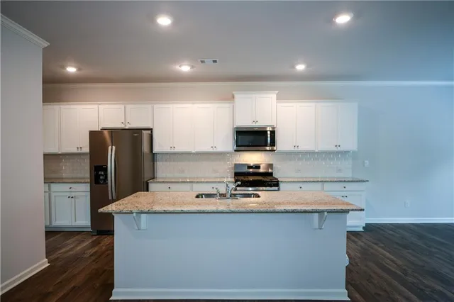 a kitchen with kitchen island microwave and refrigerator