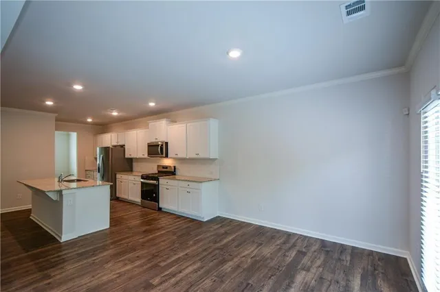 a view of kitchen with wooden floor and electronic appliances