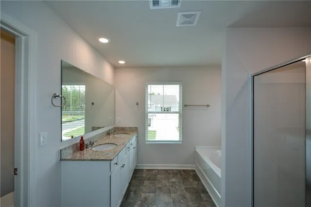 a bathroom with a granite countertop sink and mirror with window