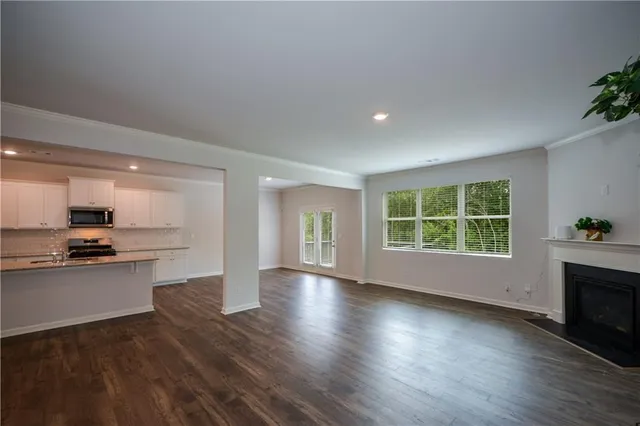 a view of empty room with kitchen and window
