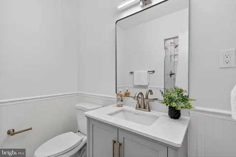 a bathroom with a sink a toilet and mirror