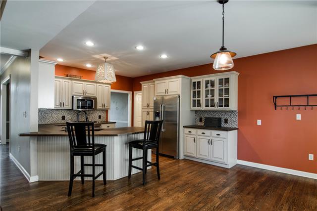 1216 Camp Ravine Road Burns, TN 37029 - Photo 8 of 20 a kitchen with stainless steel appliances kitchen island granite countertop a table chairs and a refrigerator