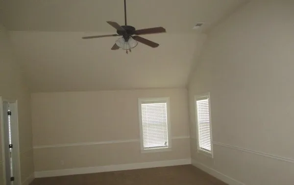 a view of empty room with window and fan
