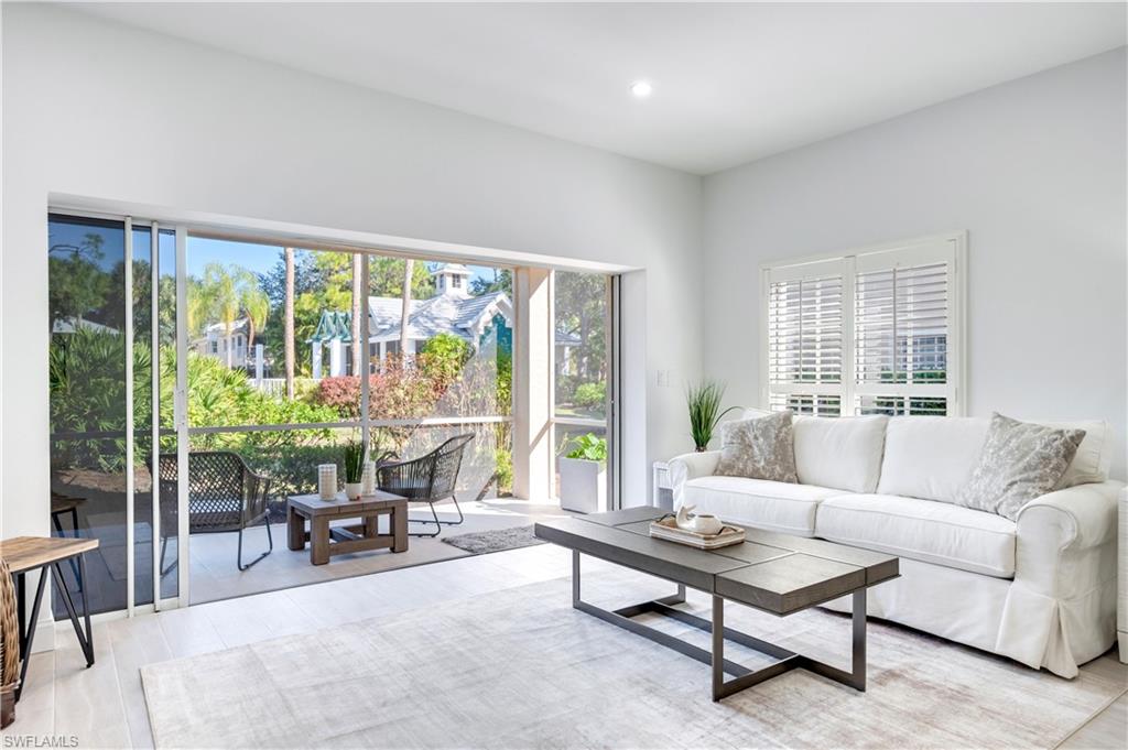 2806 Aintree Lane, Unit H102 Naples, FL 34112 - Photo 6 of 26 Sunroom / solarium with wood finished floors and a textured wall