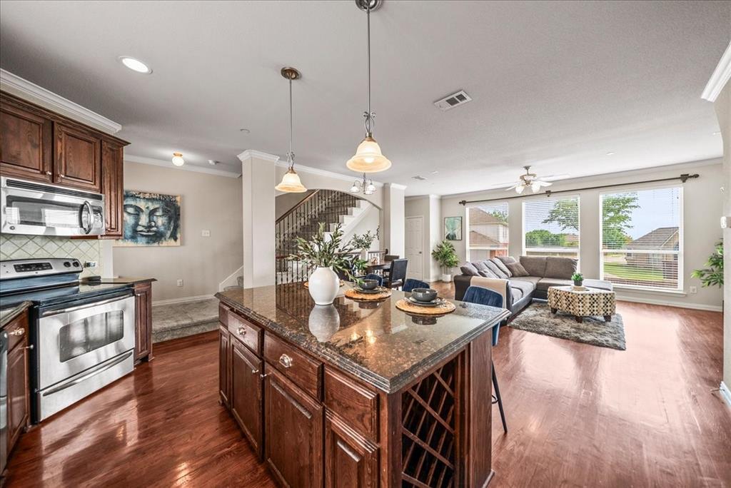 2700 Club Ridge Drive, Unit 34 Lewisville, TX 75067 - Photo 12 of 27 a kitchen with stainless steel appliances granite countertop a stove and a wooden floors