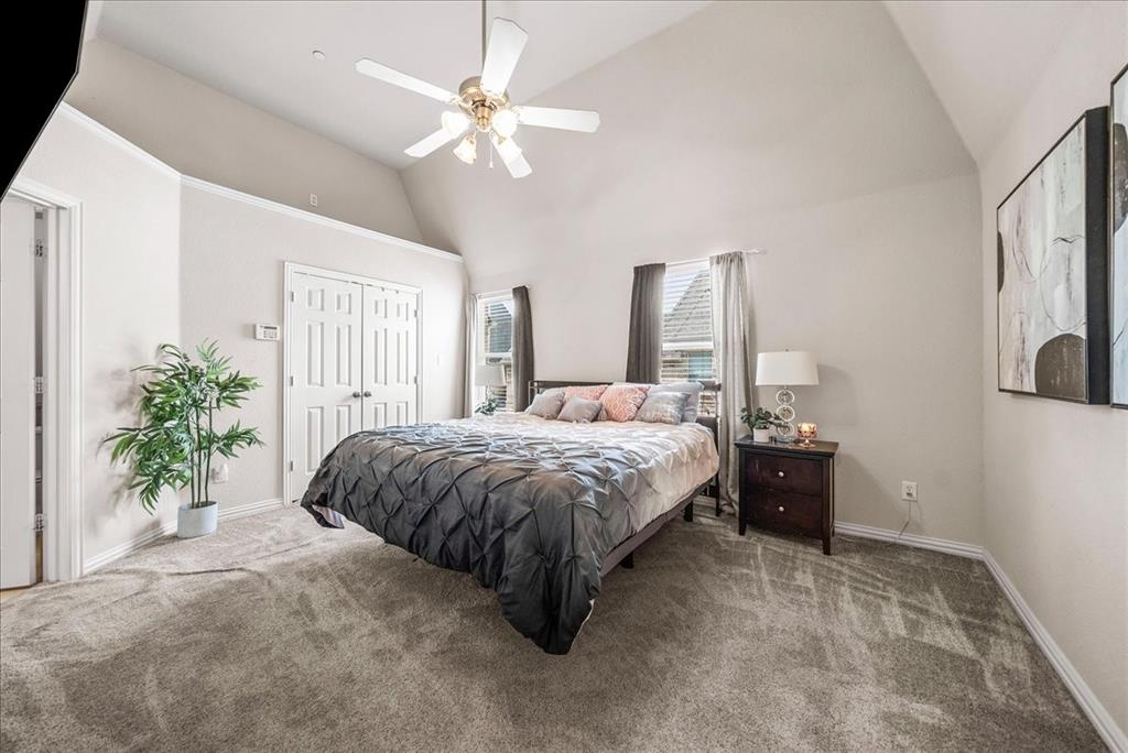 2700 Club Ridge Drive, Unit 34 Lewisville, TX 75067 - Photo 16 of 27 a spacious bedroom with a large bed and a chandelier