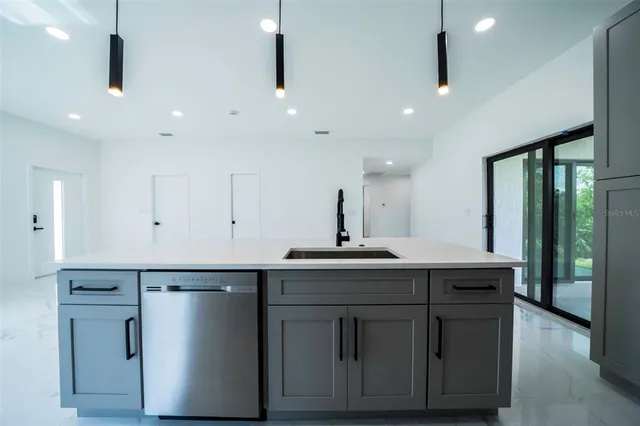 a kitchen with kitchen island a sink stainless steel appliances and cabinets