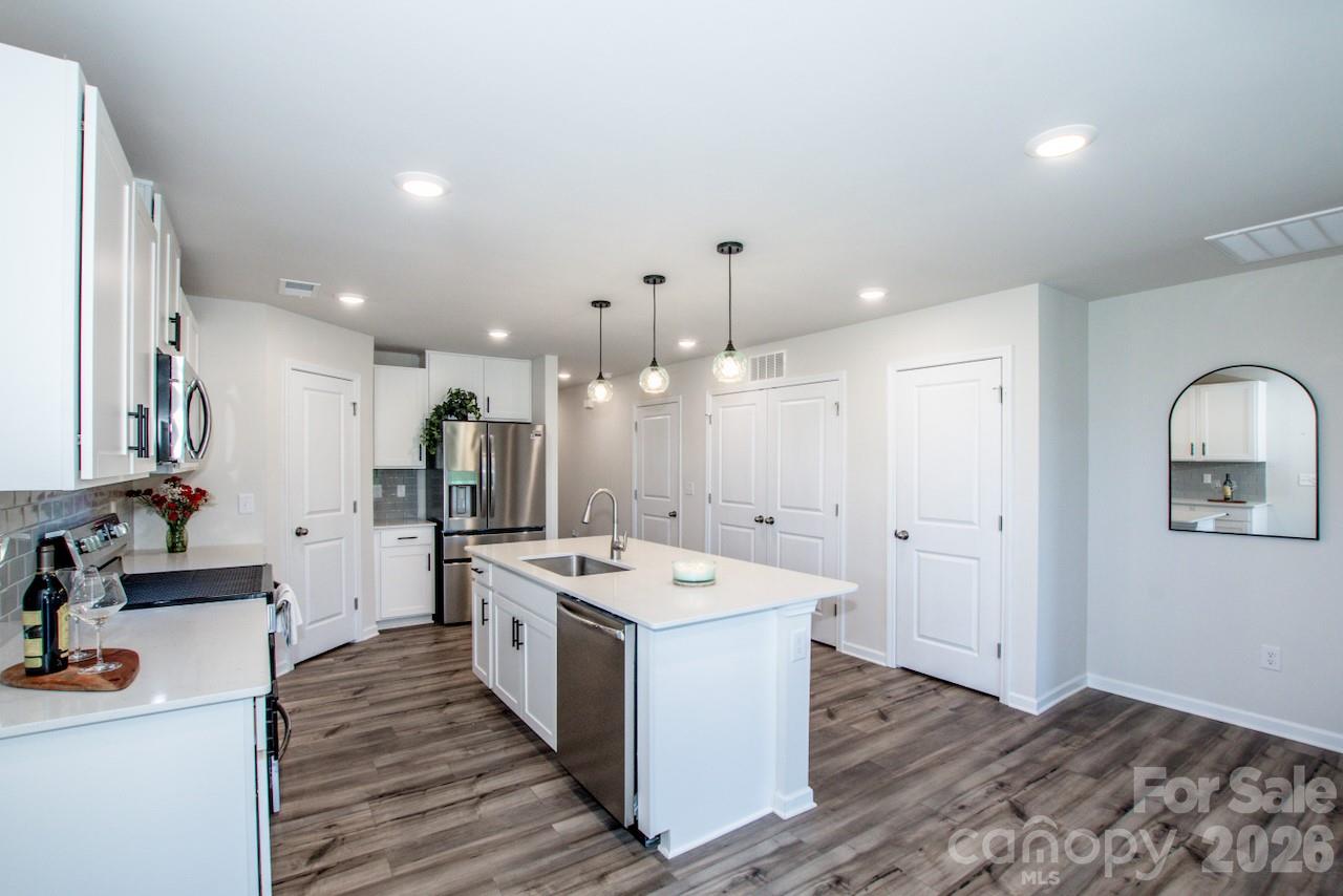 2742 Legacy Ridge Lane Catawba, NC 28609 - Photo 18 of 36 a large white kitchen with a stove a sink dishwasher and a refrigerator with wooden floor
