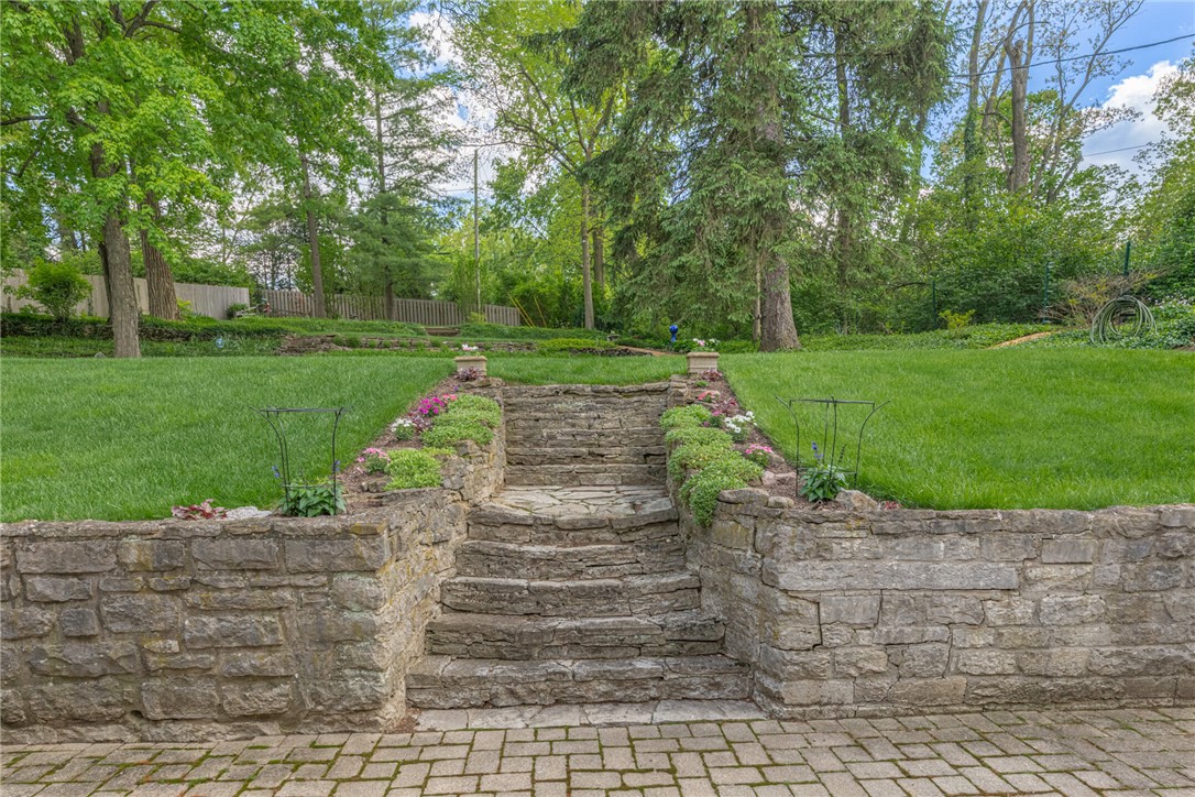 156 West Hadley Road Dayton, OH 45419 - Photo 47 of 71 Stone steps lead to an expansive lawn framed by mature trees and lush greenery.
