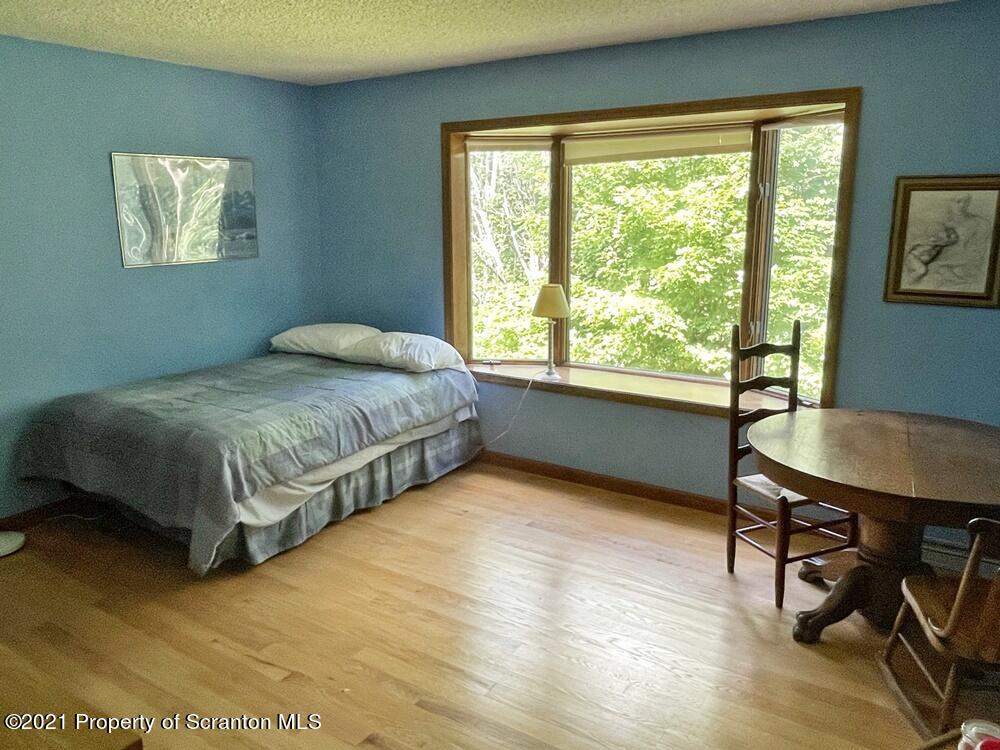 2480 Madisonville Road Moscow, PA 18444 - Photo 14 of 22 a bedroom with a bed a table and a dresser next to a window
