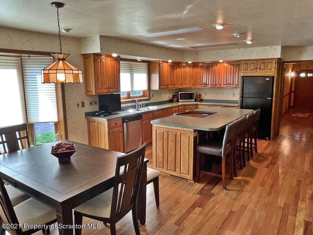 2480 Madisonville Road Moscow, PA 18444 - Photo 8 of 22 a kitchen with stainless steel appliances granite countertop a sink a stove a dining table and chairs