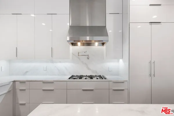 a kitchen with stainless steel appliances kitchen island granite countertop a stove a sink and a refrigerator