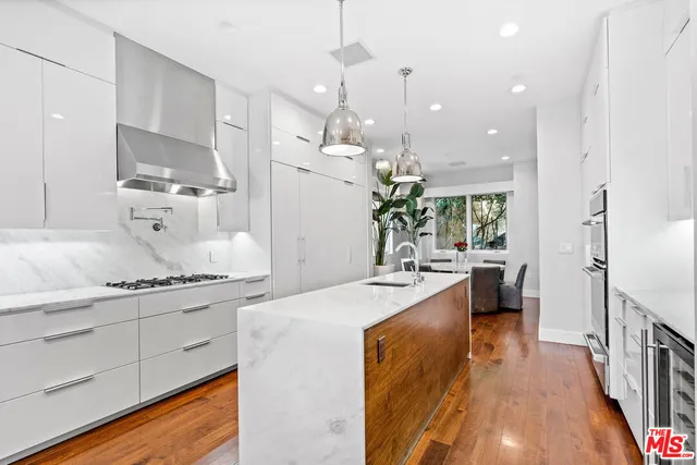a kitchen with a refrigerator and white cabinets
