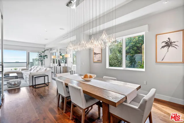 a view of a dining room with furniture a chandelier and wooden floor