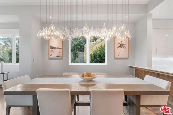 a view of a dining room with furniture a chandelier and window
