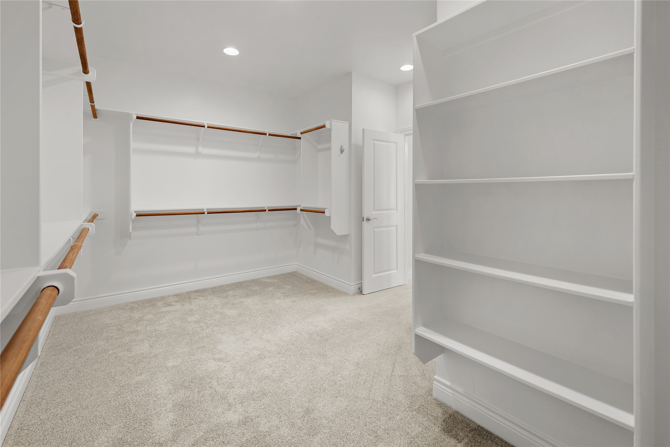 955 Inka Road Salado, TX 76571 - Photo 11 of 39 A spacious walk-in closet features plush carpeting, recessed lighting, and extensive built-in shelving.