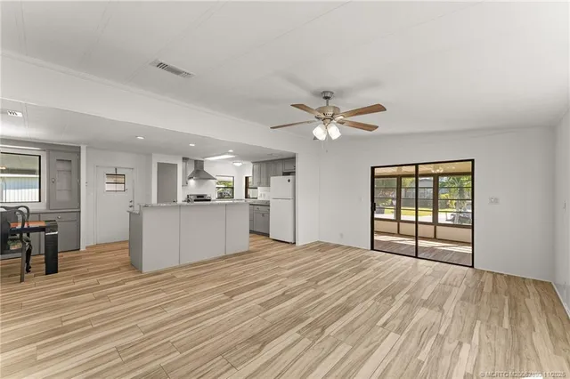 a view of a kitchen with wooden floor and a window