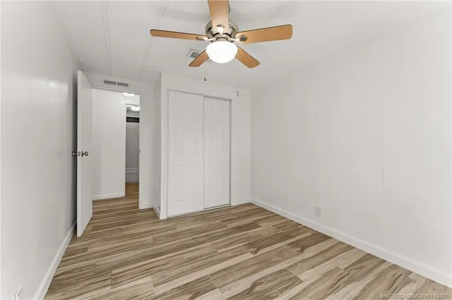 a view of a livingroom with wooden floor and a ceiling fan