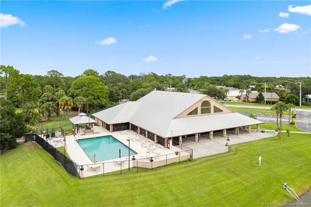 a view of a house with a big yard and large trees