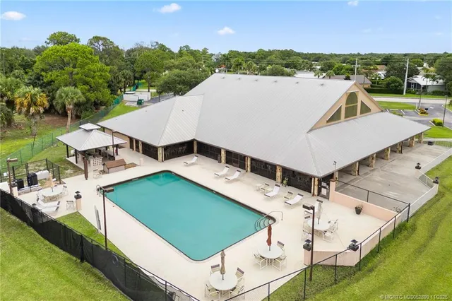 an aerial view of a house with swimming pool and lake view