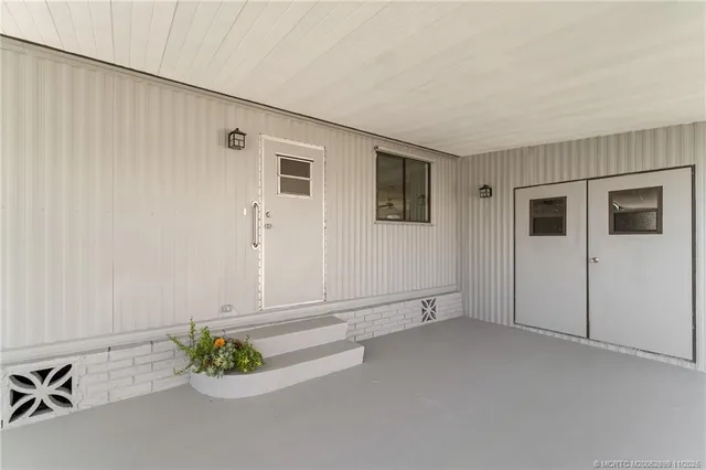 an empty room with potted plants and wooden floor
