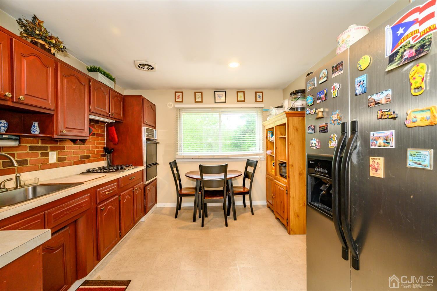 11 Atlantic Road Somerset, NJ 08873 - Photo 11 of 35 a kitchen with stainless steel appliances granite countertop a refrigerator a stove a sink dishwasher and a dining table with the kitchen view
