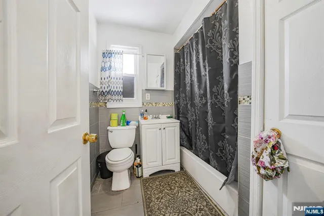 a bathroom with a toilet sink and shower curtain