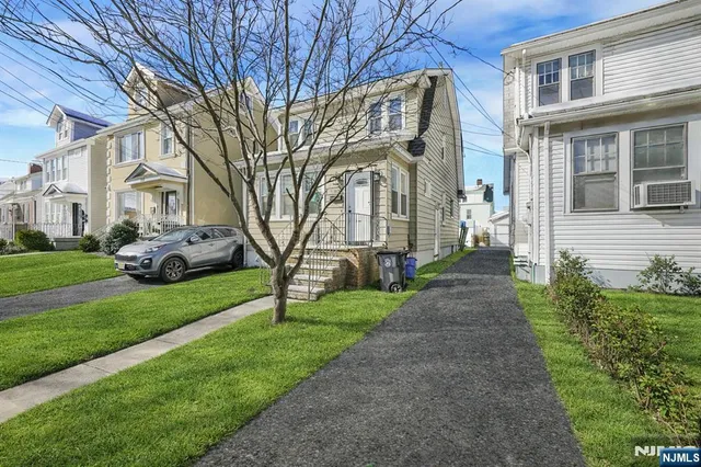 a front view of a house with a garden and trees
