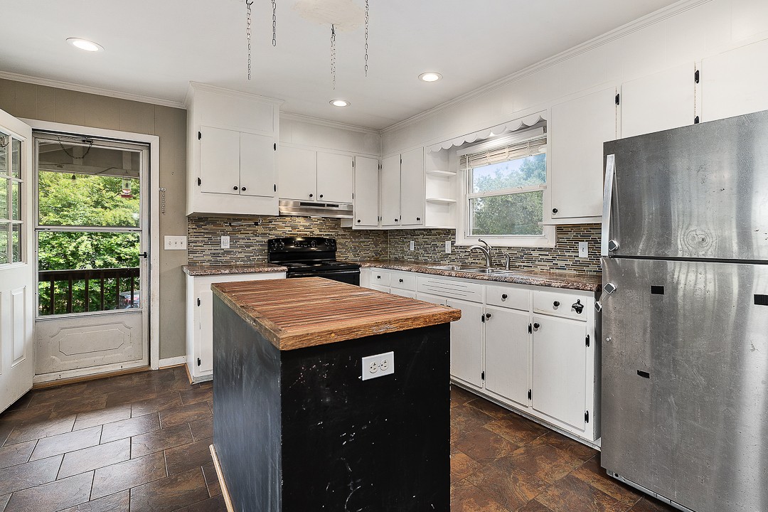 1823 Evins Mill Road Smithville, TN 37166 - Photo 5 of 19 a kitchen with stainless steel appliances granite countertop a stove a refrigerator a sink and white cabinets with wooden floor