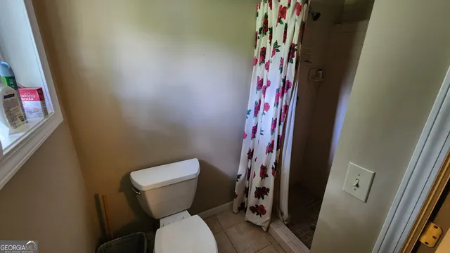 a white toilet sitting next to a shower curtain