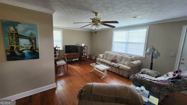 a living room with furniture and a wooden floor