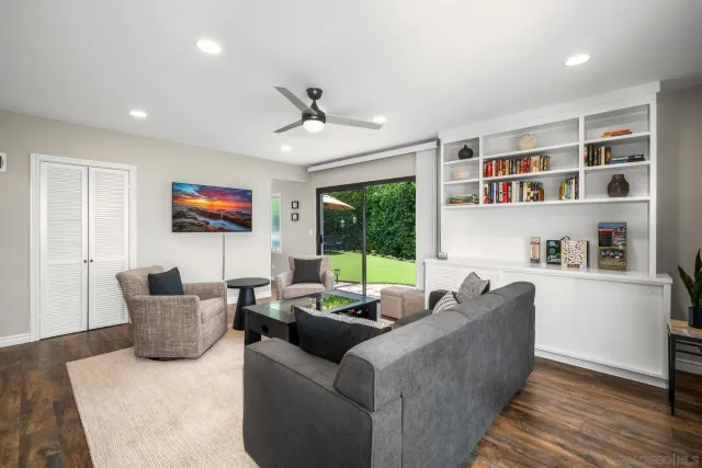 a view of a patio with couches table and chairs under an umbrella