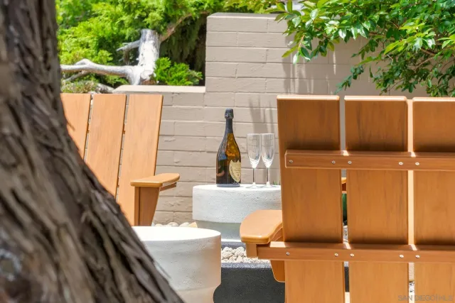 a view of a patio with couches table and chairs under an umbrella