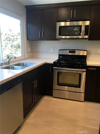a kitchen with stainless steel appliances a stove a sink and a microwave