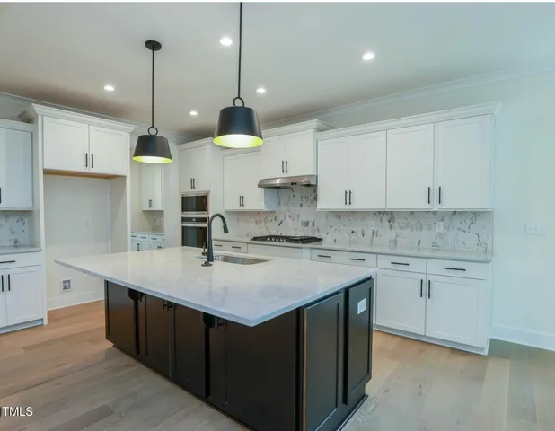 a kitchen with a sink stove cabinets and refrigerator