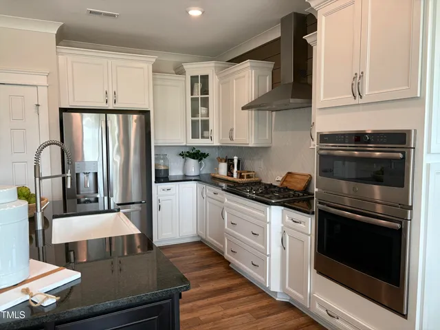 a kitchen with stainless steel appliances granite countertop a stove a sink and a refrigerator