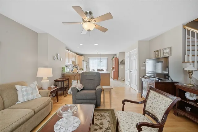 a living room with furniture kitchen view and a chandelier