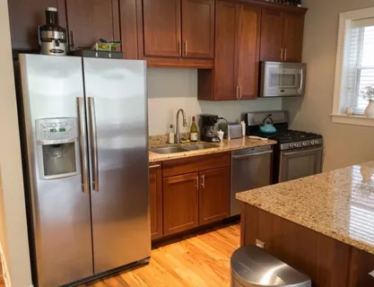 a kitchen with stainless steel appliances granite countertop a refrigerator sink and cabinets