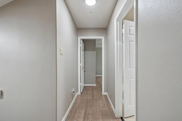 a view of a hallway with wooden floor