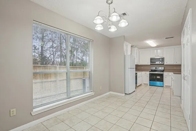 a view of a kitchen with microwave and refrigerator