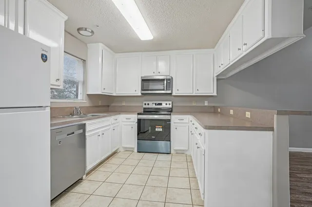a kitchen with granite countertop a stove top oven sink and cabinets