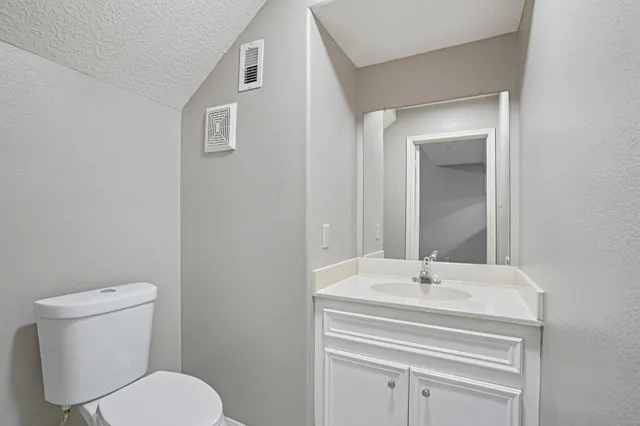 a bathroom with a sink mirror and toilet