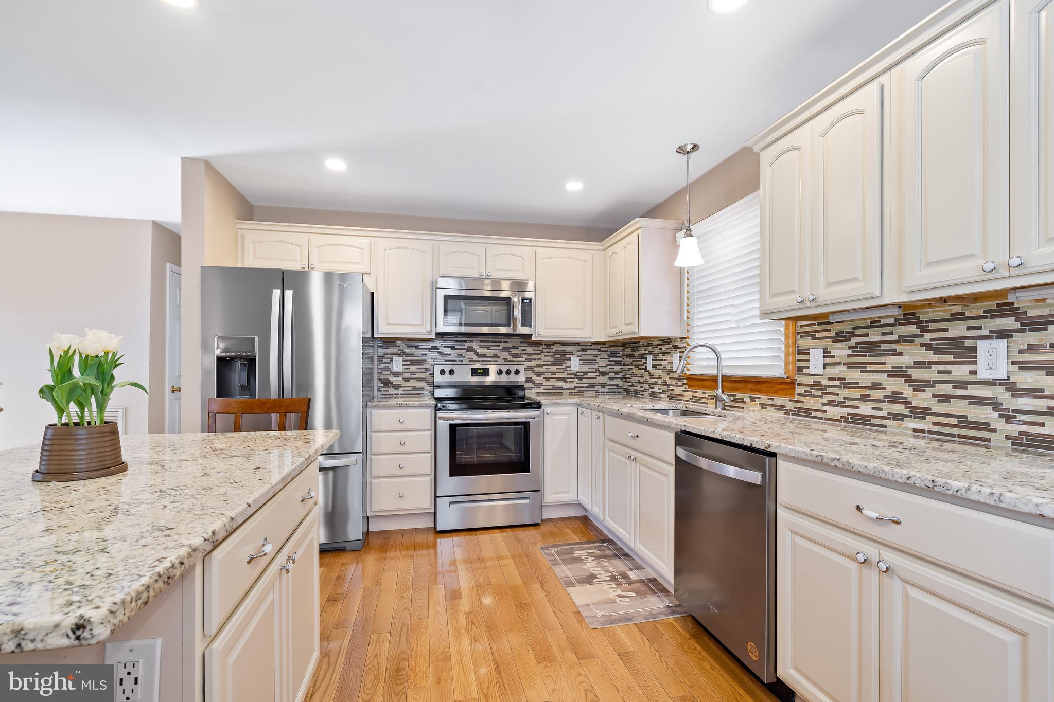 7 Weed Lane Elkton, MD 21921 - Photo 7 of 34 a kitchen with granite countertop a stove a sink dishwasher a refrigerator and white cabinets with wooden floor