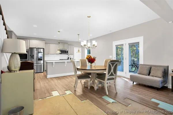 a living room with furniture and a dining table with kitchen view