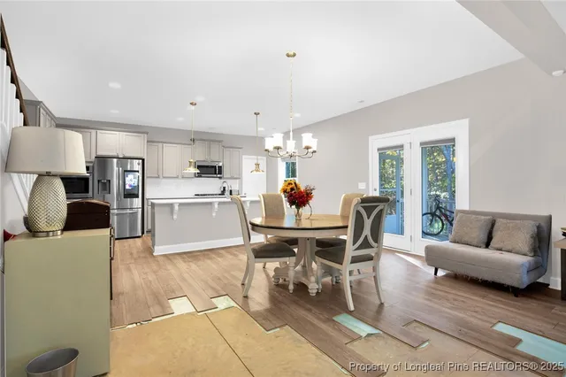a living room with furniture and a dining table with kitchen view