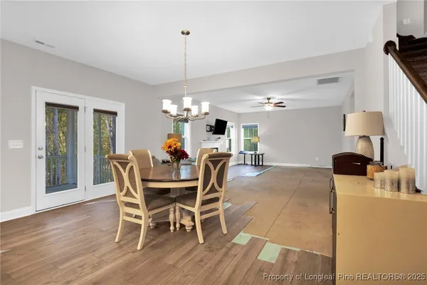 a dining room with furniture a chandelier and wooden floor