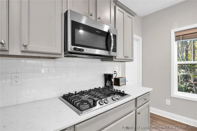 a kitchen with stainless steel appliances a white cabinet and a stove top oven