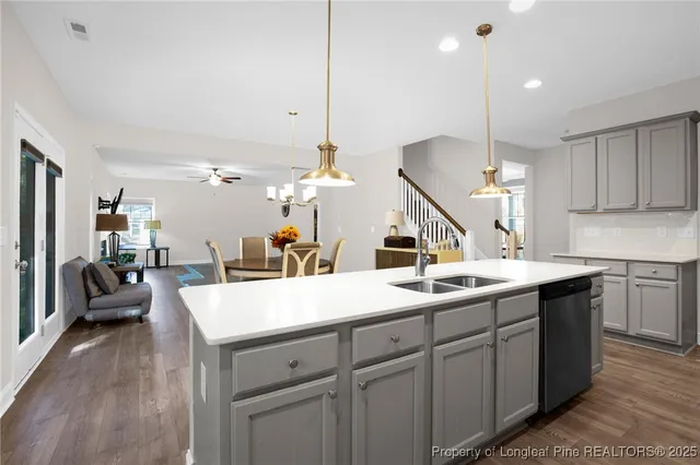 a kitchen with a sink a counter space appliances and cabinets